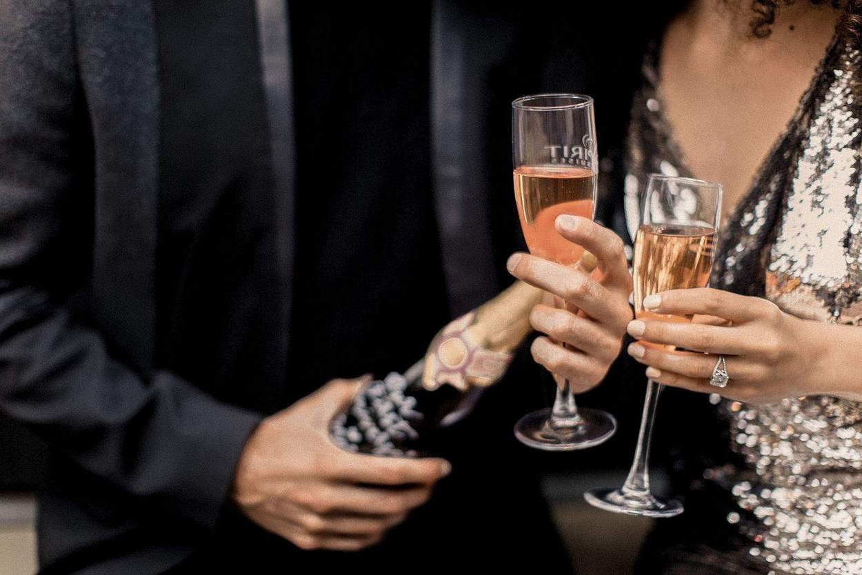 Close-up of two champagne flutes, a bottle and an engagement ring during an Old Town Alexandria engagement session.