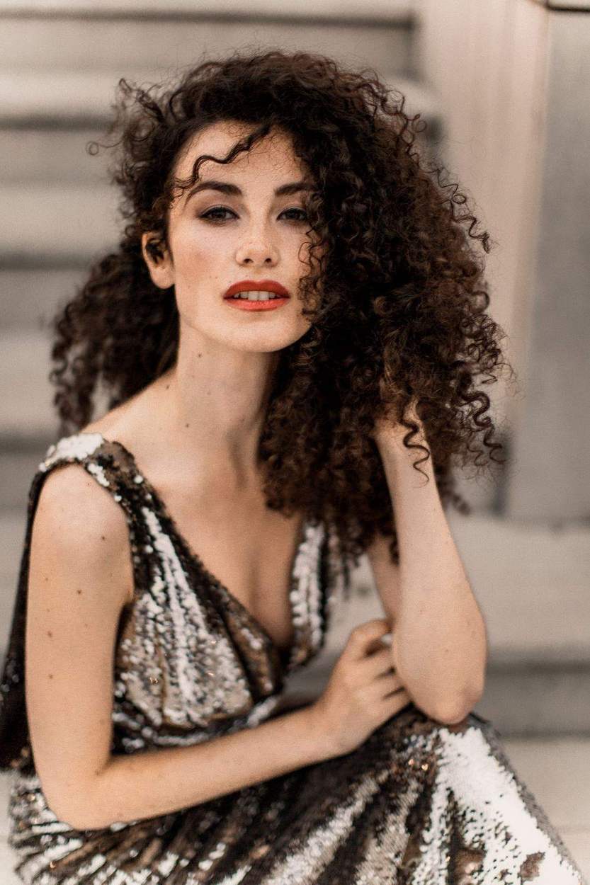 Close portrait of a woman with curly hair and red lipstick in a silver sequin gown, Old Town Alexandria engagement session.